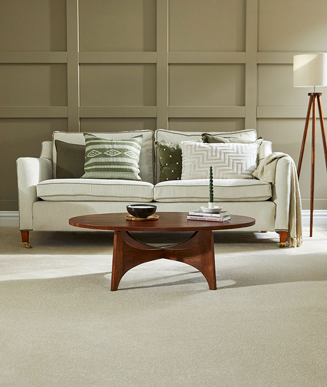 Deep cream Cormar Zenith carpet on living room floor with green panelling and cream sofa.
